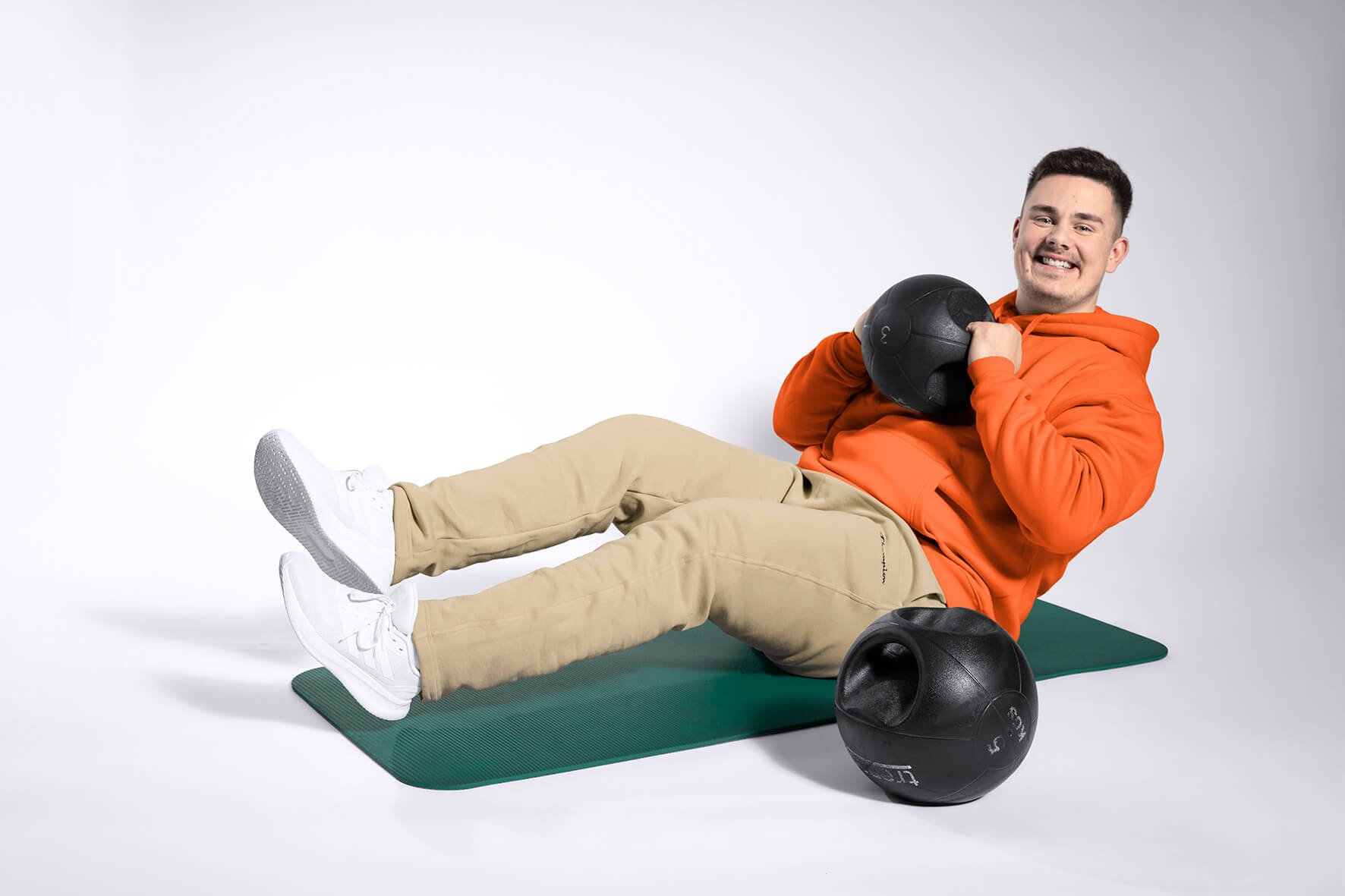 Teilnehmer trainiert mit Medizinball auf der Matte